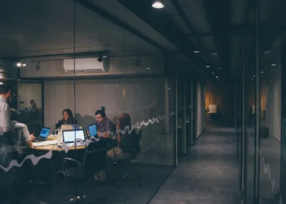 Pessoas reunidas em um escritório com pouca luminosidade